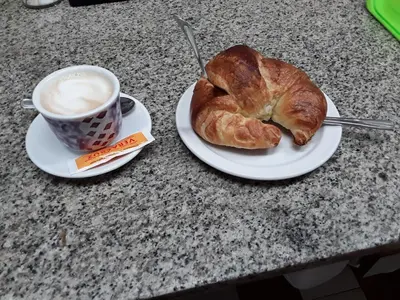 a plate with a croissant and a cup of coffee at A Concha in Lavacolla