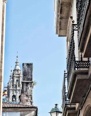 a view of the se cathedral from between buildings at Pensión O Códice by Moradas Nieto in Santiago de Compostela