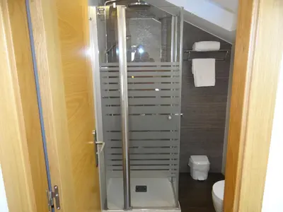a glass shower in a bathroom with a toilet at Pensión O Códice by Moradas Nieto in Santiago de Compostela