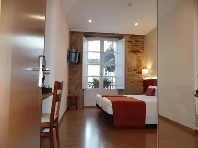 a hotel room with a bed and a window at Pensión O Códice by Moradas Nieto in Santiago de Compostela