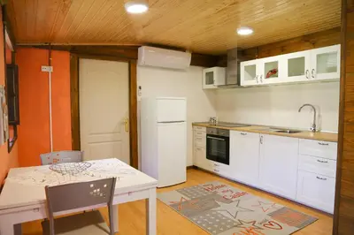 a kitchen with a table and a white refrigerator at Casa Juca in La Teijeira