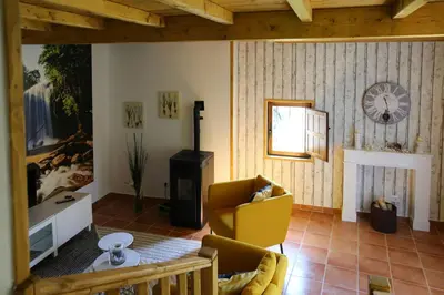 a living room with a chair and a clock on the wall at Casa Juca in La Teijeira