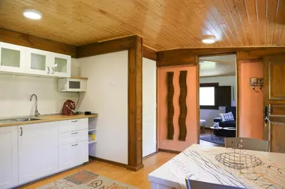 a kitchen with white cabinets and a wooden ceiling at Casa Juca in La Teijeira