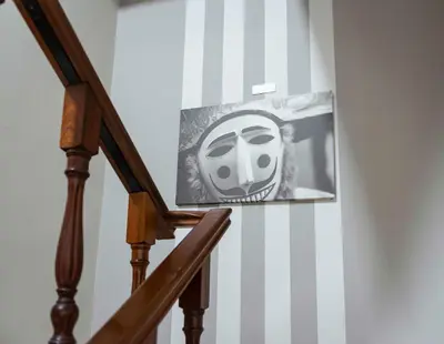 a picture of a mask on the side of a staircase at A Morada do Cigarron in Verín