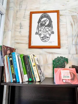 a shelf with books and pictures on a wall at A Morada do Cigarron in Verín