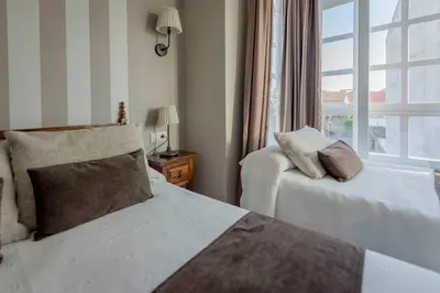 a hotel room with two beds and a window at A Morada do Cigarron in Verín