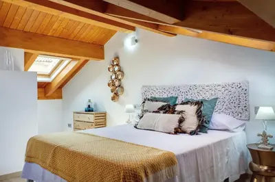 a bedroom with a bed with a wooden ceiling at Numa Rúa Travesa in Santiago de Compostela