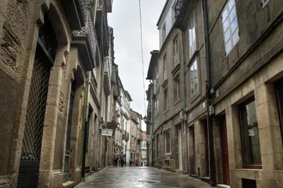 an empty street in a city with buildings at Numa Rúa Travesa in Santiago de Compostela