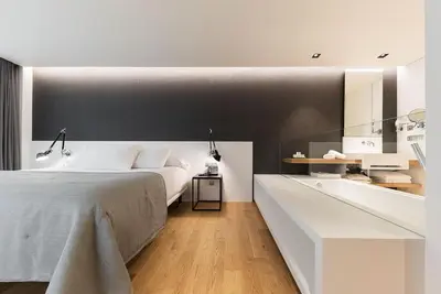 a bedroom with a large bed and a bath tub at Hotel U Viveiro in Viveiro