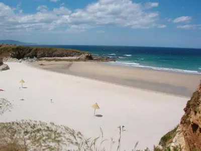 a white beach with the ocean in the background at Casa do Merlo in Barreiros