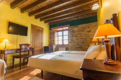 a bedroom with a bed and a desk and a tv at Casa do Merlo in Barreiros