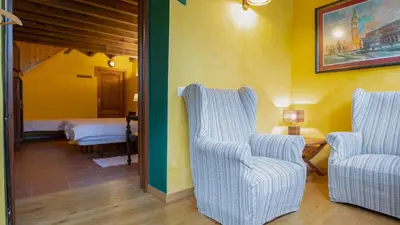 a living room with two chairs and a bed at Casa do Merlo in Barreiros