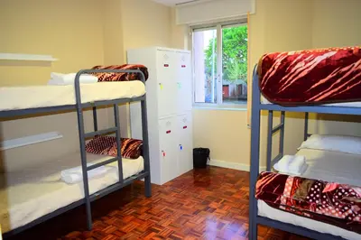 a room with three bunk beds and a window at Albergue Mirás in Sigüeiro