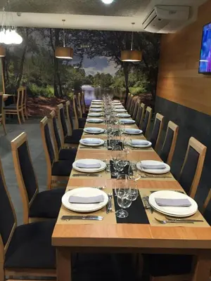 a long table with plates and wine glasses on it at Albergue Mirás in Sigüeiro