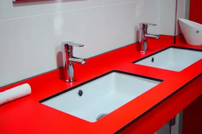 two sinks in a red counter with two faucets at Albergue Mirás in Sigüeiro