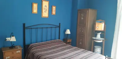 a bedroom with a bed and a blue wall at Casa Antonio y Benina in Sosas de Laciana