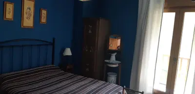 a bedroom with a bed and a blue wall at Casa Antonio y Benina in Sosas de Laciana