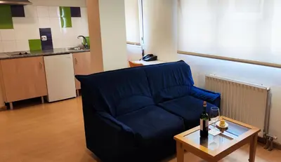 a living room with a blue couch and a table at Hotel Metropol by Carris in Lugo