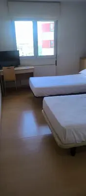 a room with two beds and a desk and two windows at Hotel Metropol by Carris in Lugo