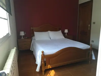 a bedroom with a bed with white pillows and a window at Pensión Restaurante Casa Camiño II in Palas de Rei