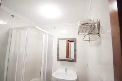 a white bathroom with a sink and a mirror at Pensión Restaurante Casa Camiño II in Palas de Rei