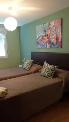 a bedroom with a bed and a painting on the wall at Castelao Apartments in Arzúa
