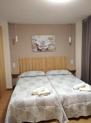 two beds in a room with two beds sidx sidx sidx at Castelao Apartments in Arzúa