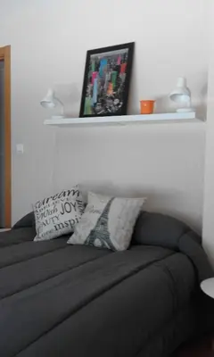 a bedroom with a couch with pillows and a shelf at Castelao Apartments in Arzúa