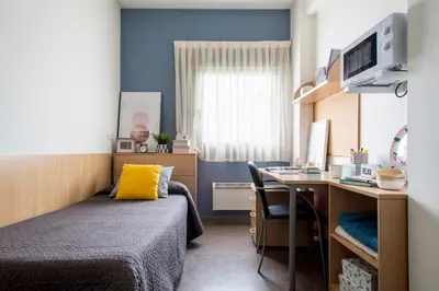 a bedroom with a bed and a desk with a computer at Residencia Universitaria Resa As Burgas in Ourense