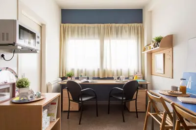 a kitchen with a table and chairs in a room at Residencia Universitaria Resa As Burgas in Ourense