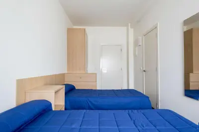 a bedroom with two beds with blue sheets at Residencia Universitaria Resa As Burgas in Ourense