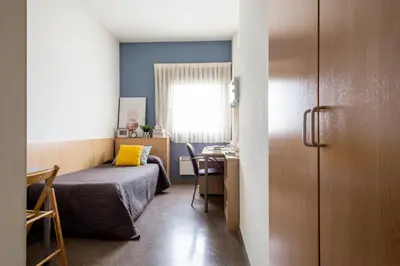 a small room with a bed and a desk and a table at Residencia Universitaria Resa As Burgas in Ourense