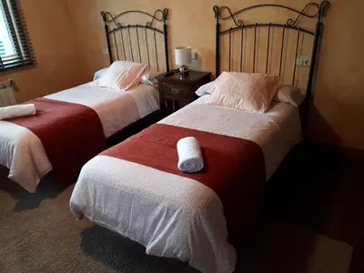 a bedroom with a bed with red pillows and two night stands at Pension Vilanova in Sigüeiro
