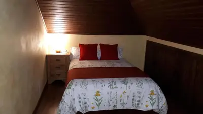 a bedroom with a white bed with red pillows and a mirror at Pension Vilanova in Sigüeiro
