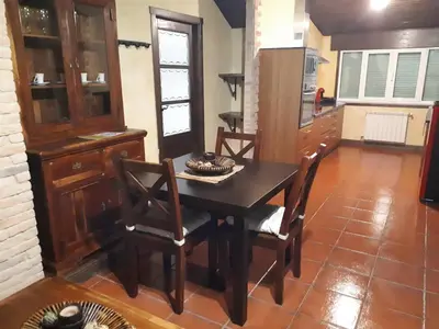 a dining room with a table and chairs and a kitchen at Pension Vilanova in Sigüeiro