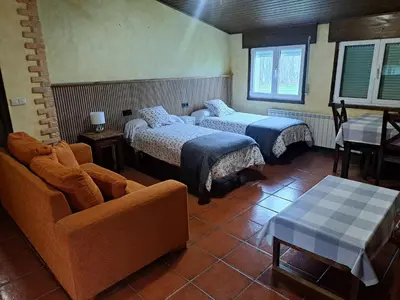 a hotel room with two beds with red and white sheets at Pension Vilanova in Sigüeiro