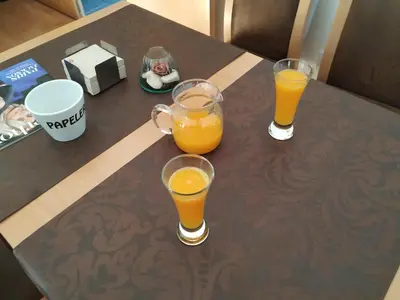 three glasses of orange juice sitting on a table at Hotel Pazo de Berbetoros in Portomarin