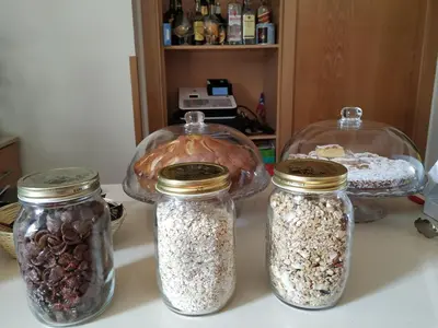 three glass jars filled with nuts and seeds on a counter at Hotel Pazo de Berbetoros in Portomarin