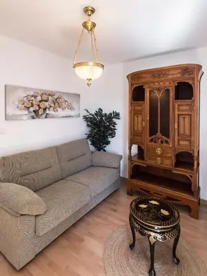 a living room with a couch and a wooden cabinet at Hotel Pazo de Berbetoros in Portomarin