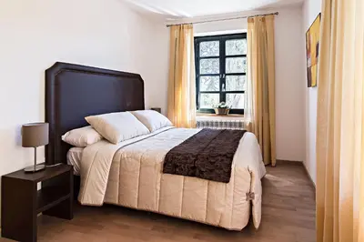 a bedroom with a large bed and a window at Hotel Pazo de Berbetoros in Portomarin