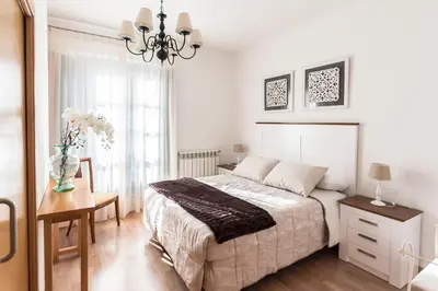 a bedroom with a bed and a table and a vase of flowers at Hotel Pazo de Berbetoros in Portomarin