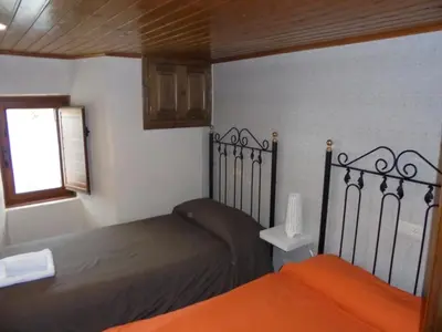 a bedroom with two beds and a window at Casa Saleta in Melide