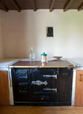 an old black oven in a room with a wall at Casa Saleta in Melide