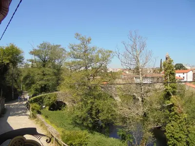 a bridge over a river with people walking down a street at Casa Saleta in Melide