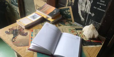 an open book sitting on top of a table with books at Pensión y Albergue Matias Locanda in Sarria