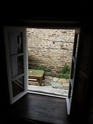 an open window with a table and a stone wall at Pensión y Albergue Matias Locanda in Sarria