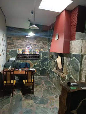 a dining room with a table and a stone wall at Pensión y Albergue Matias Locanda in Sarria