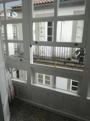 an empty room with windows and a balcony at Hostal Forest in Santiago de Compostela