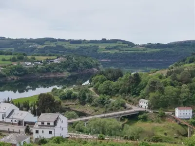 an aerial view of a town with a river and a bridge at Pension Perez in Portomarin