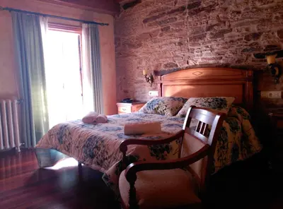 a bedroom with a bed and a chair and a window at PICO SACRO II HOTEL Santiago de Compostela in Santiago de Compostela